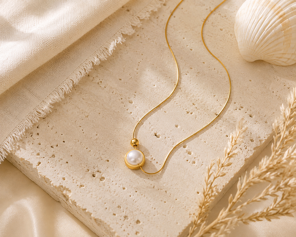 Gold pearl necklace styled in a coastal flat lay