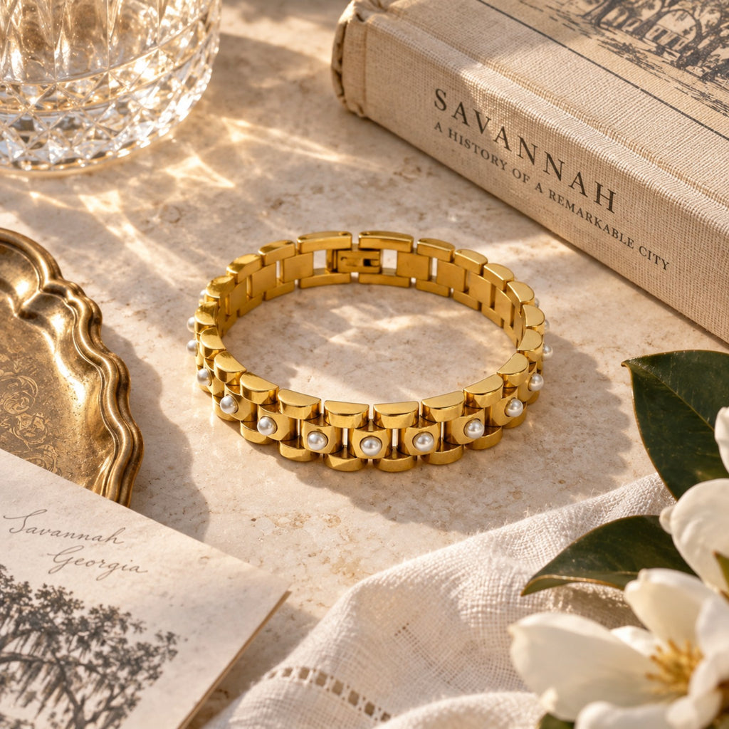 Gold link bracelet with pearl accents flat lay