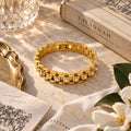 Gold link bracelet with pearl accents flat lay